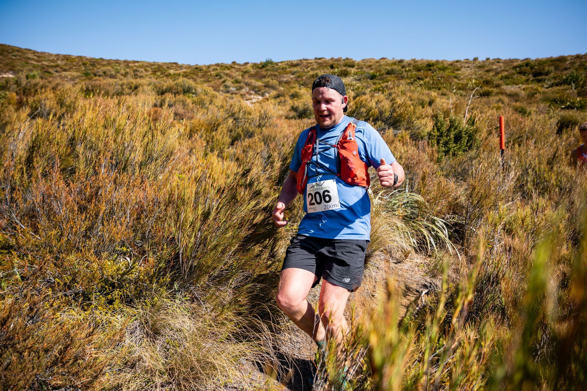 A man is running through a field with a number on his shirt.