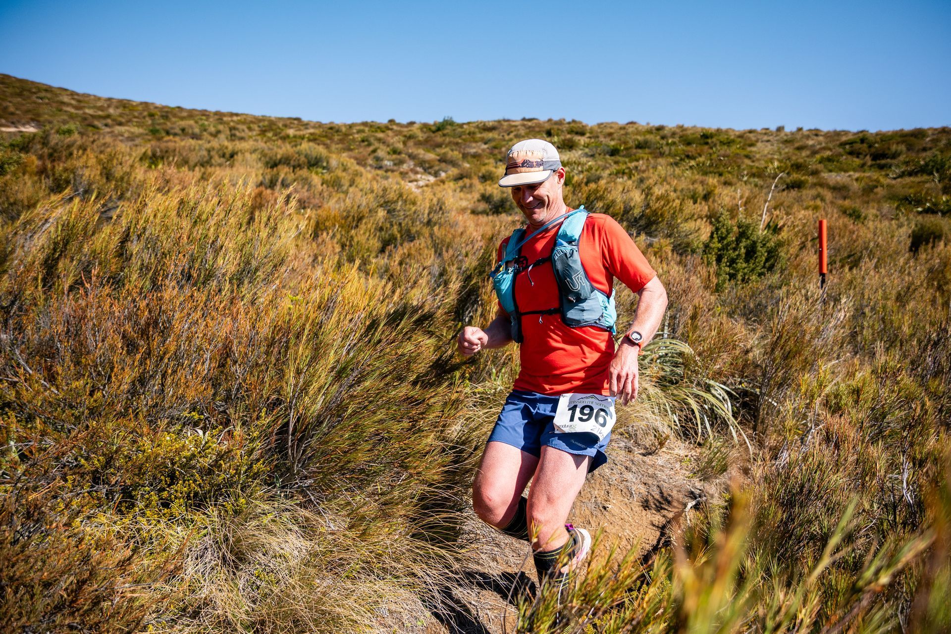 A man is running on a trail in a field.
