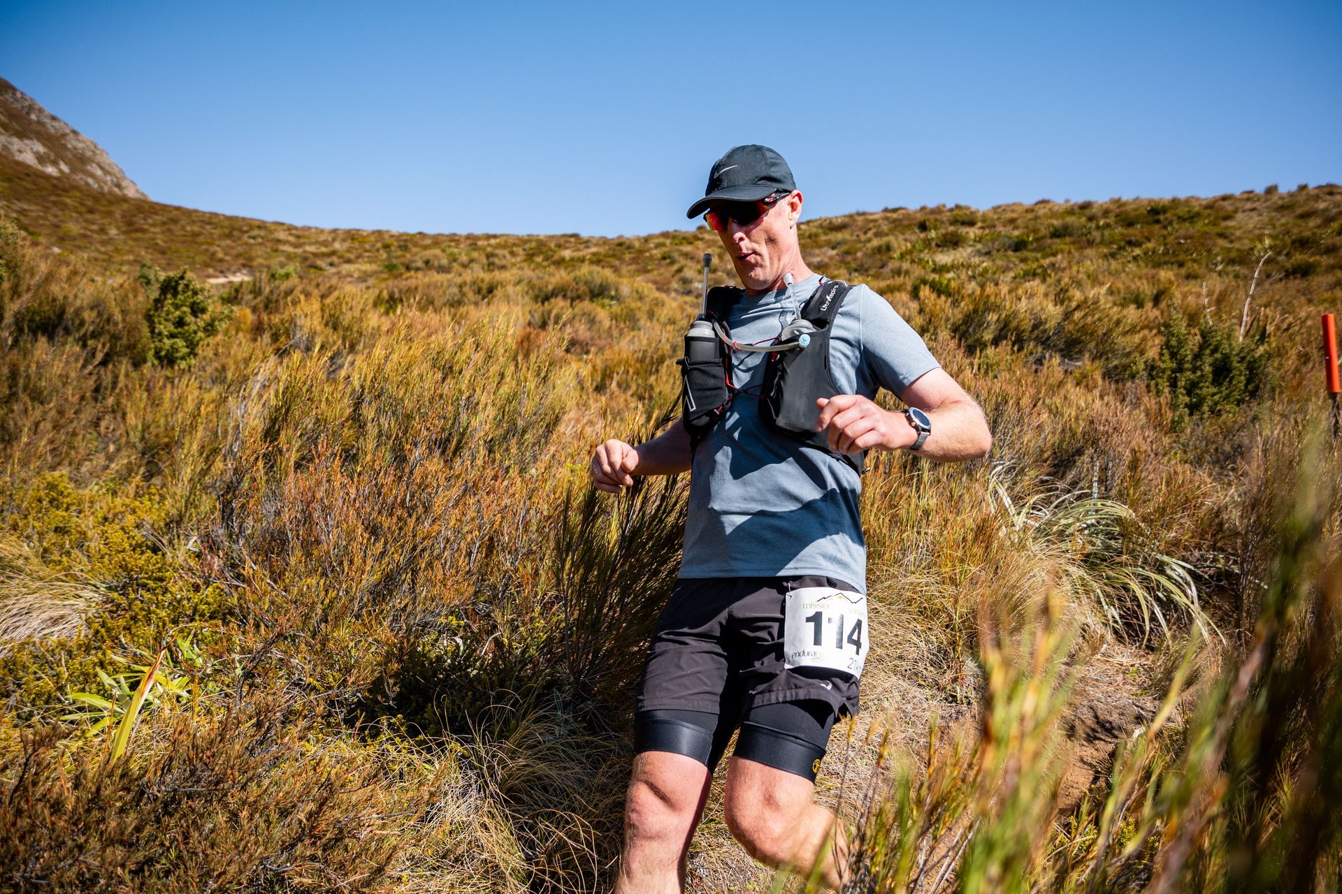 A man is running on a trail in a field.