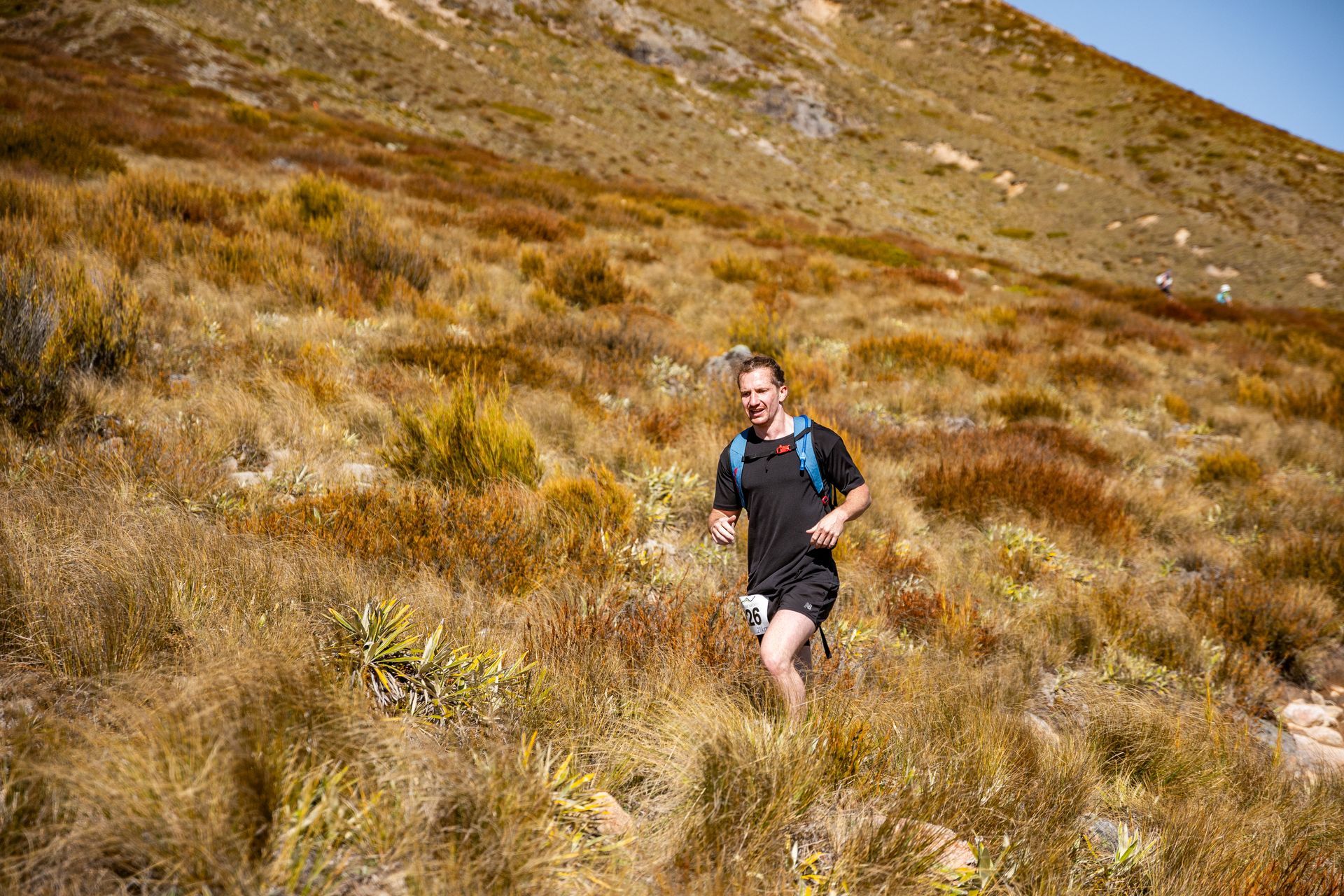 A man is running up a hill in a field.