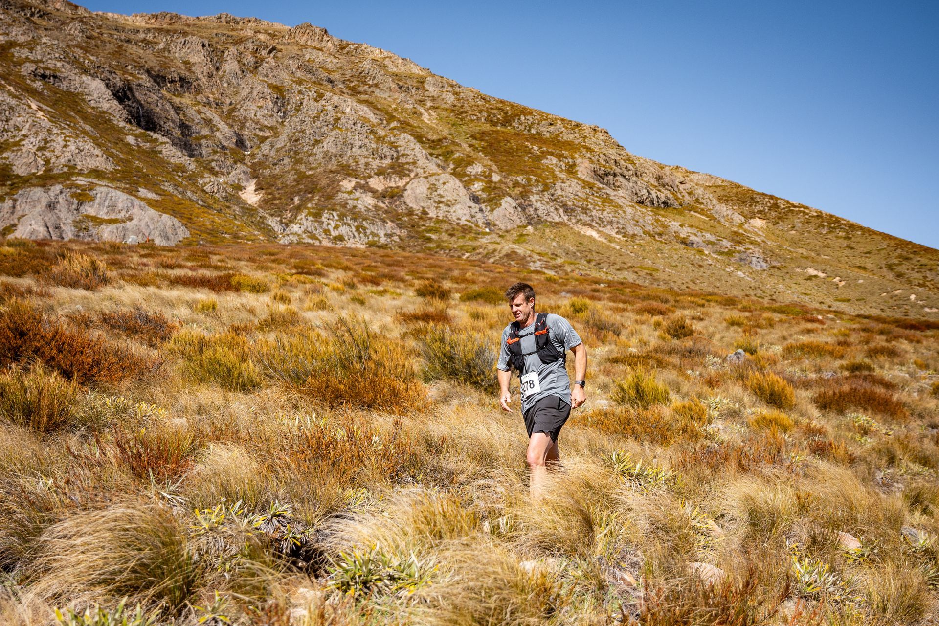 A man is running up a hill in a field.