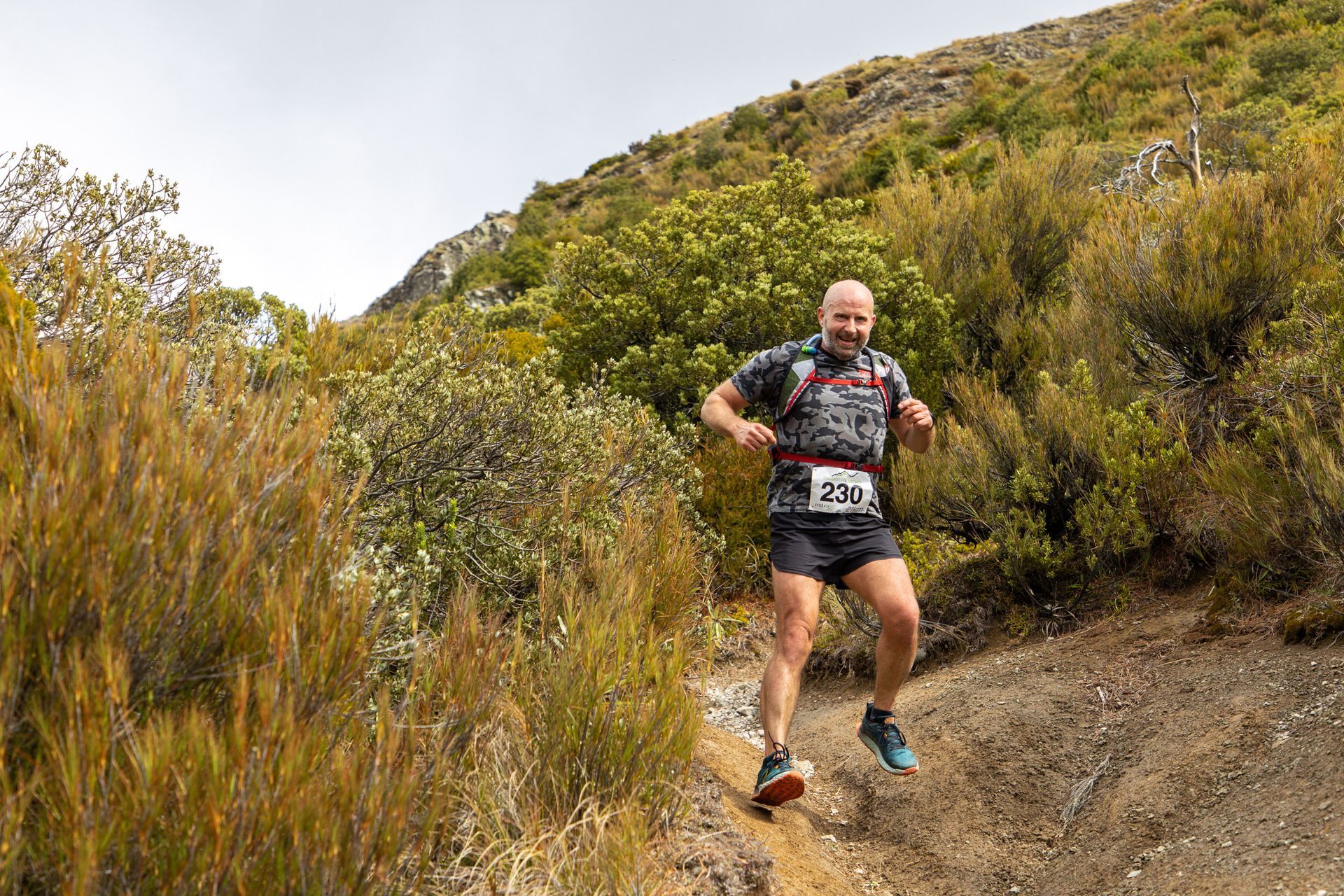A man is running on a trail in the woods.