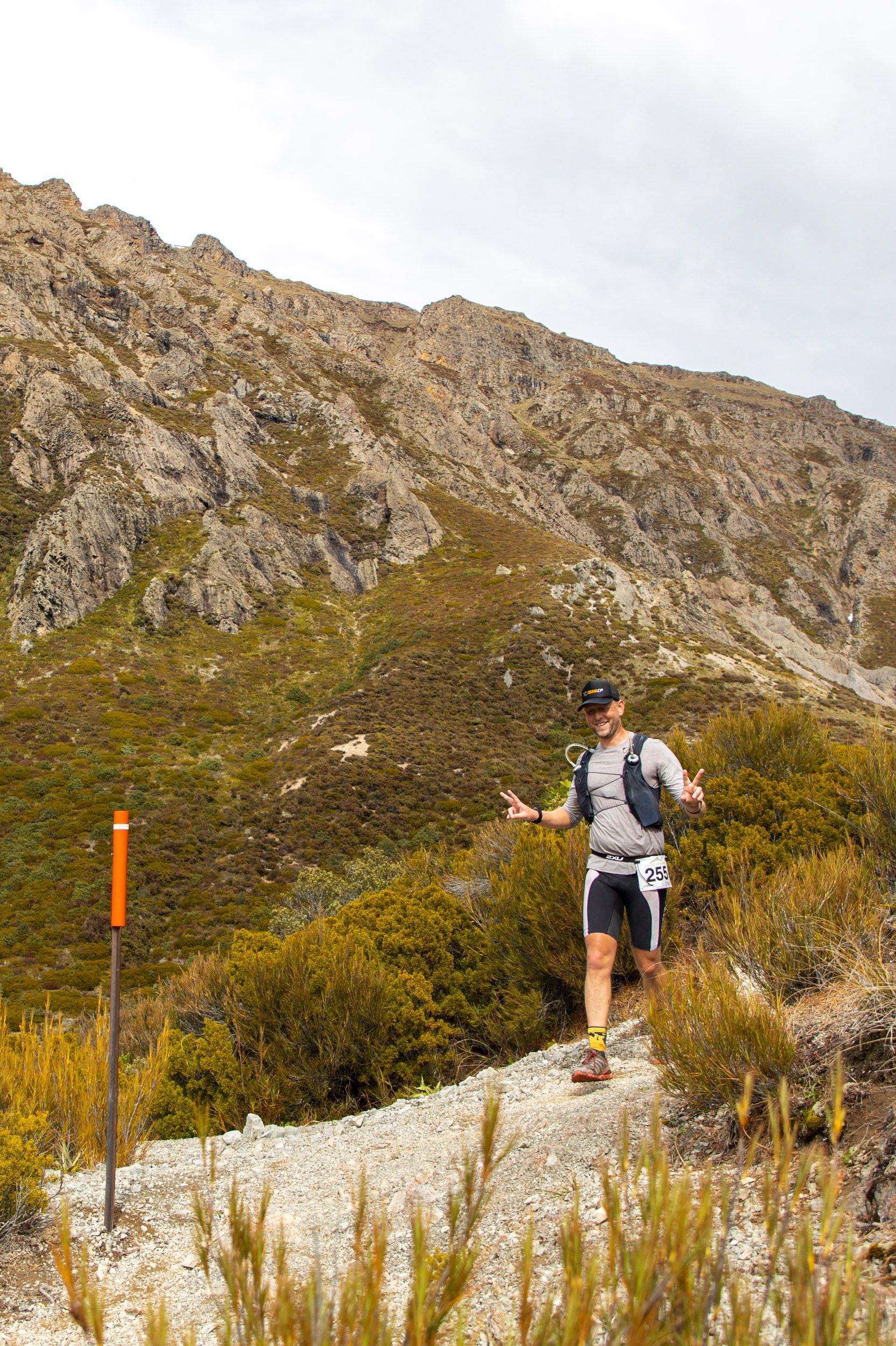 A man is running on a trail in the mountains.