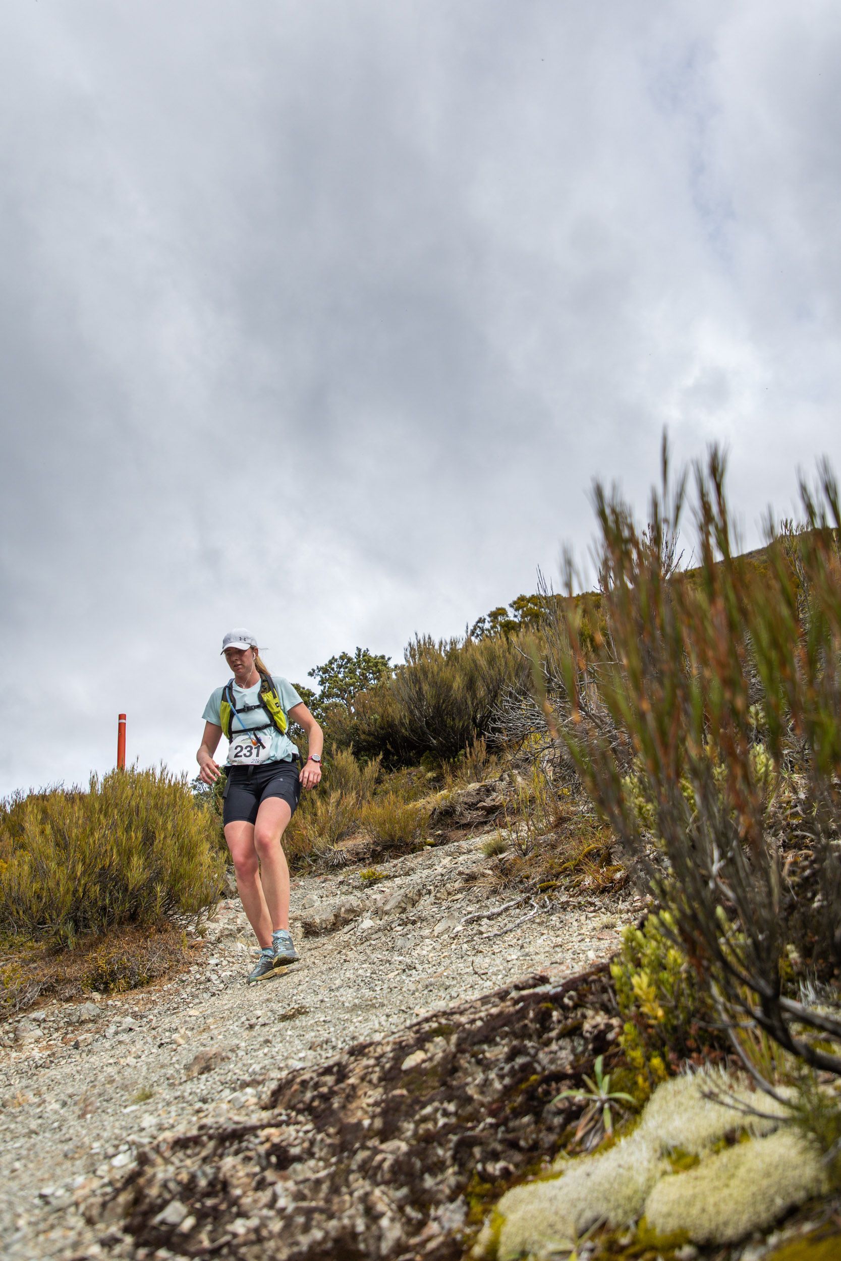 A person is running down a dirt path in the mountains.