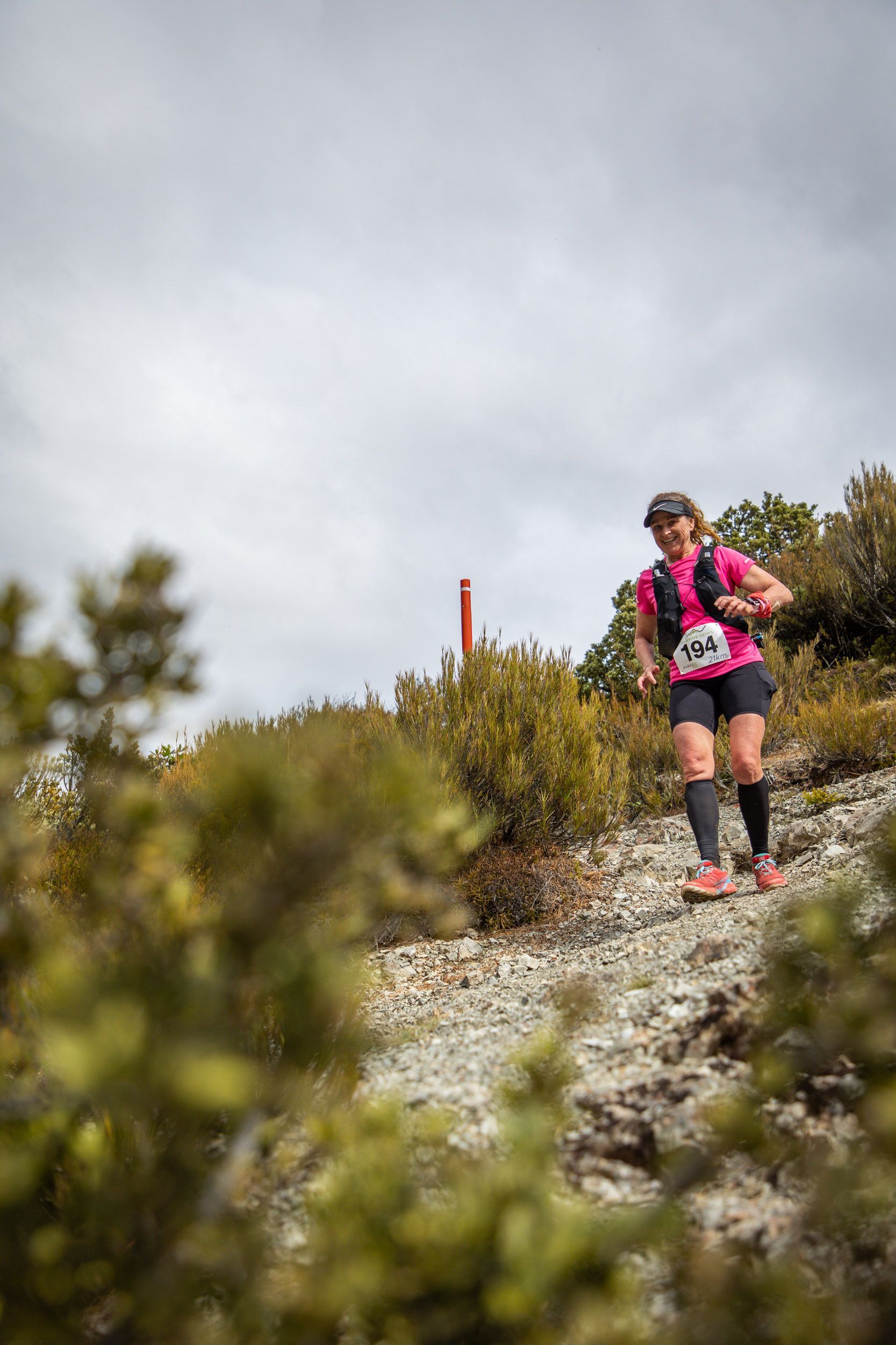 A woman is running up a hill in a trail race.