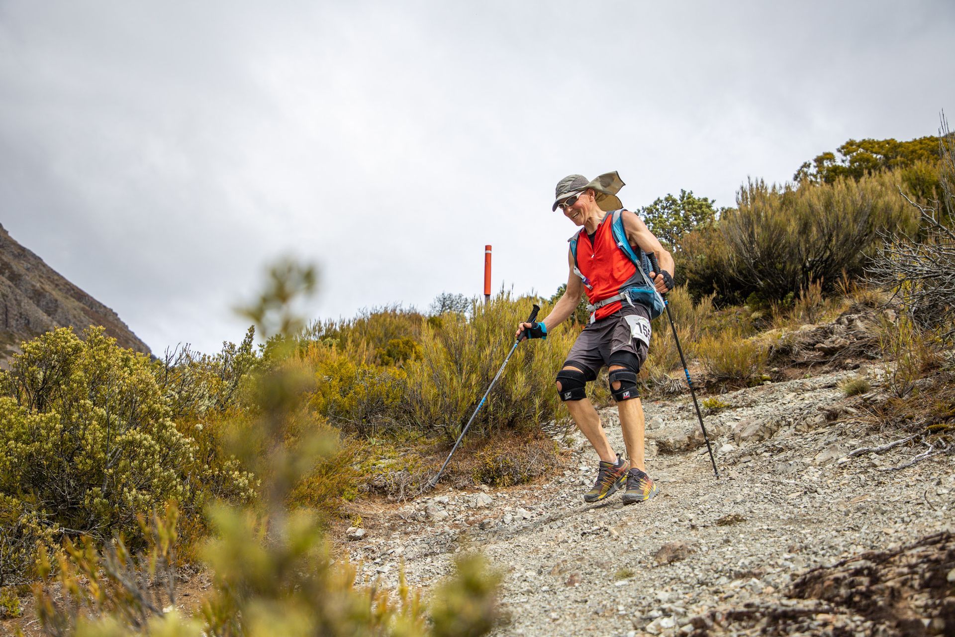 A man is hiking up a hill with hiking poles.