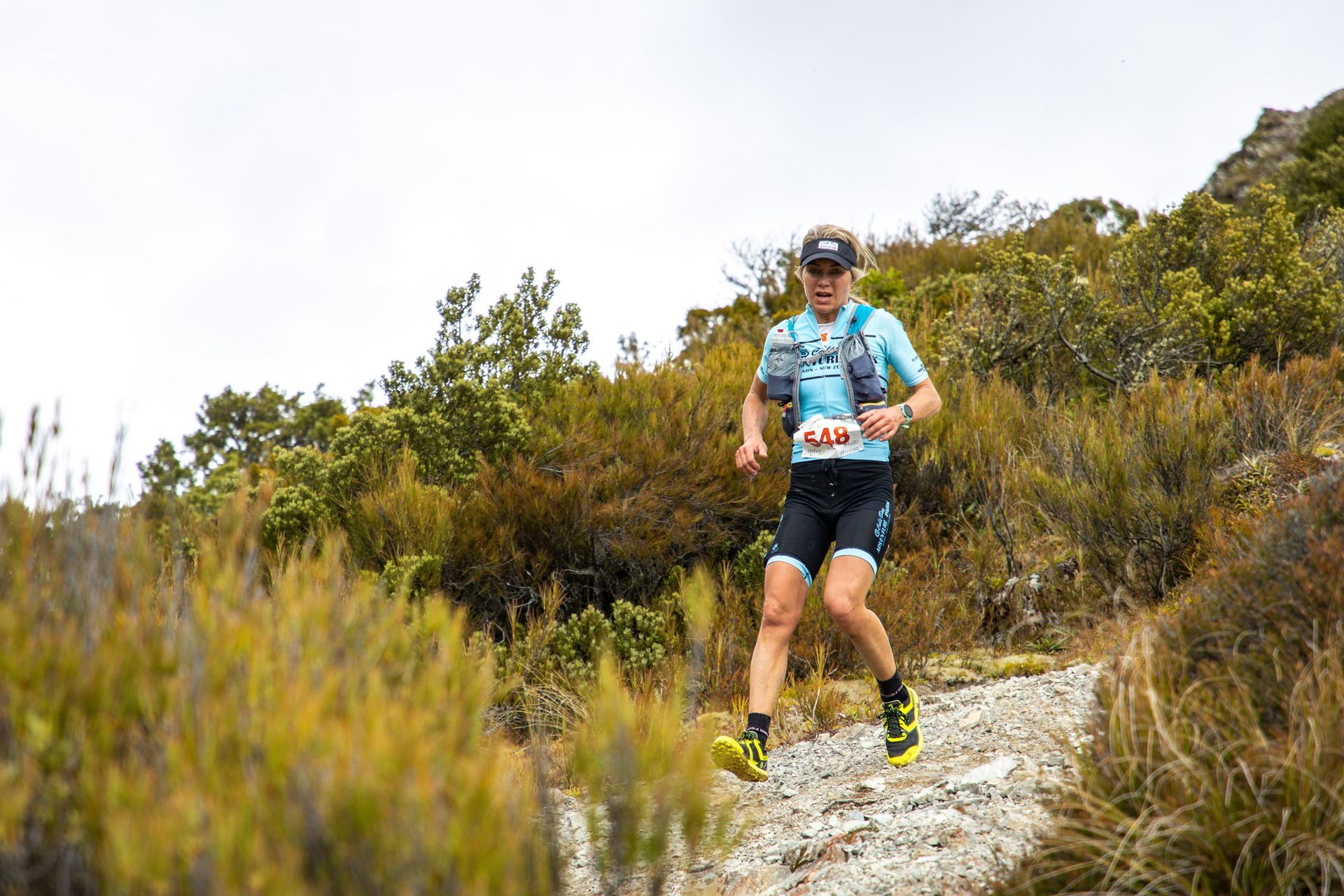 A man is running on a trail in the woods.
