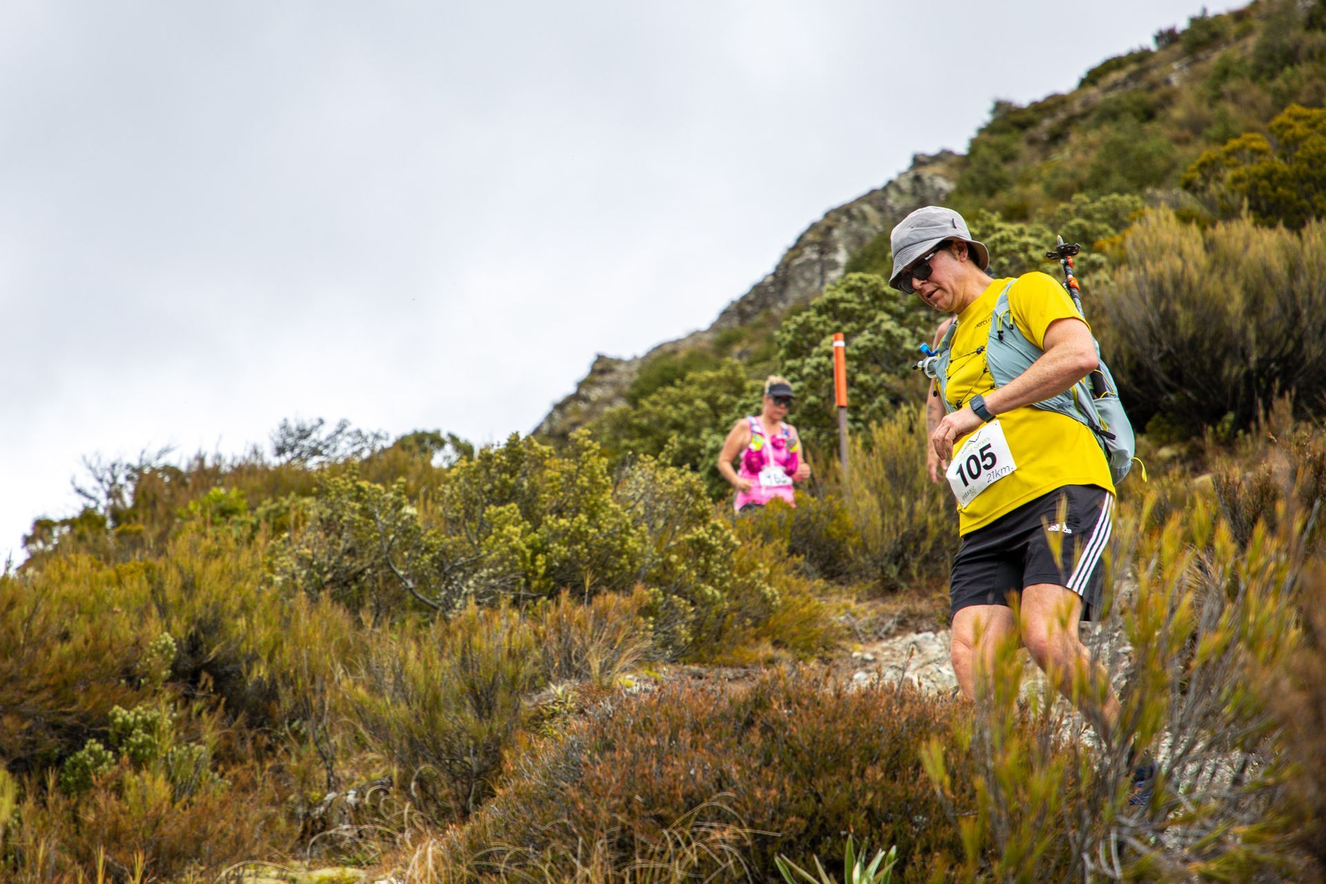 A man and a woman are running up a hill.