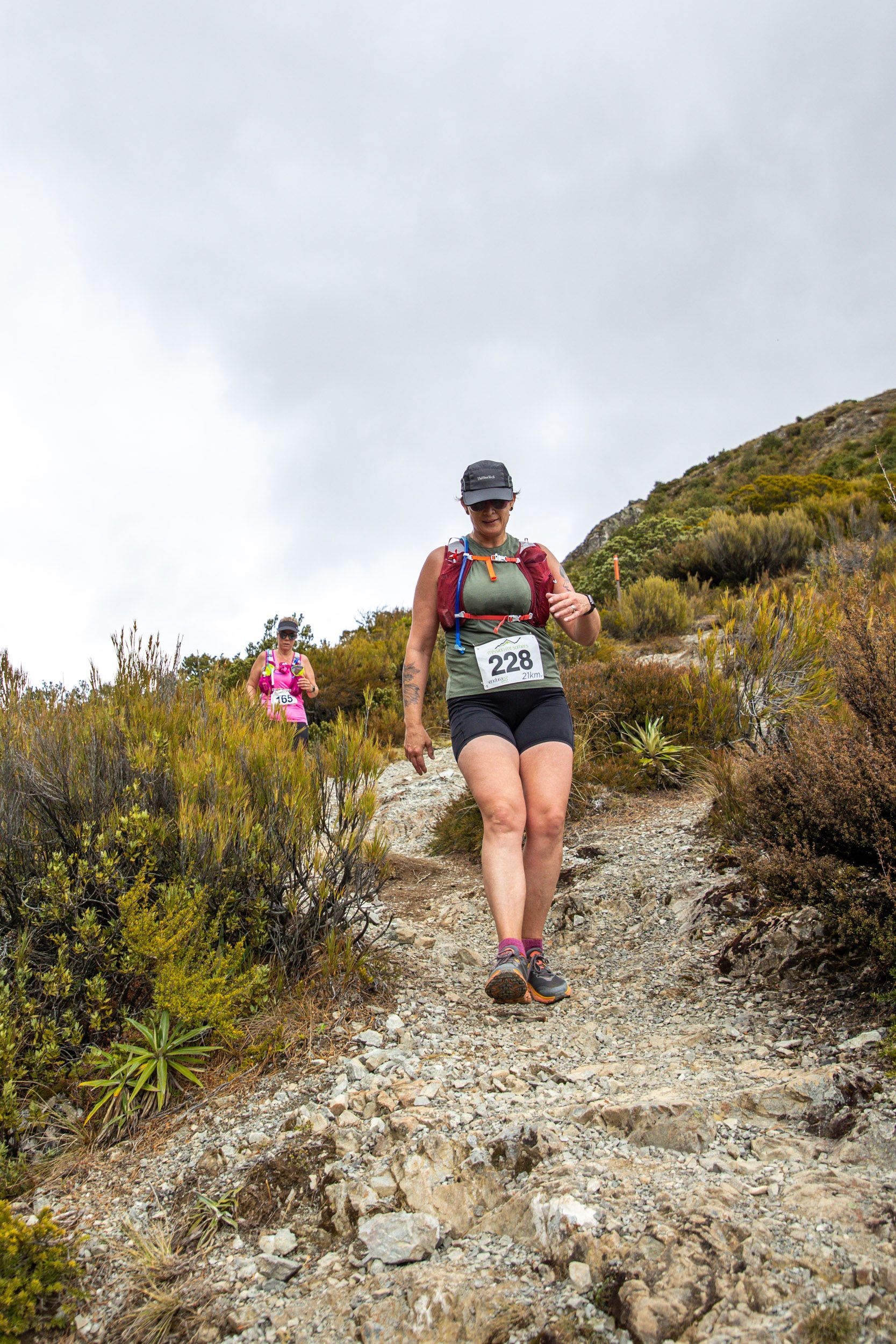 A woman is walking up a rocky hill.