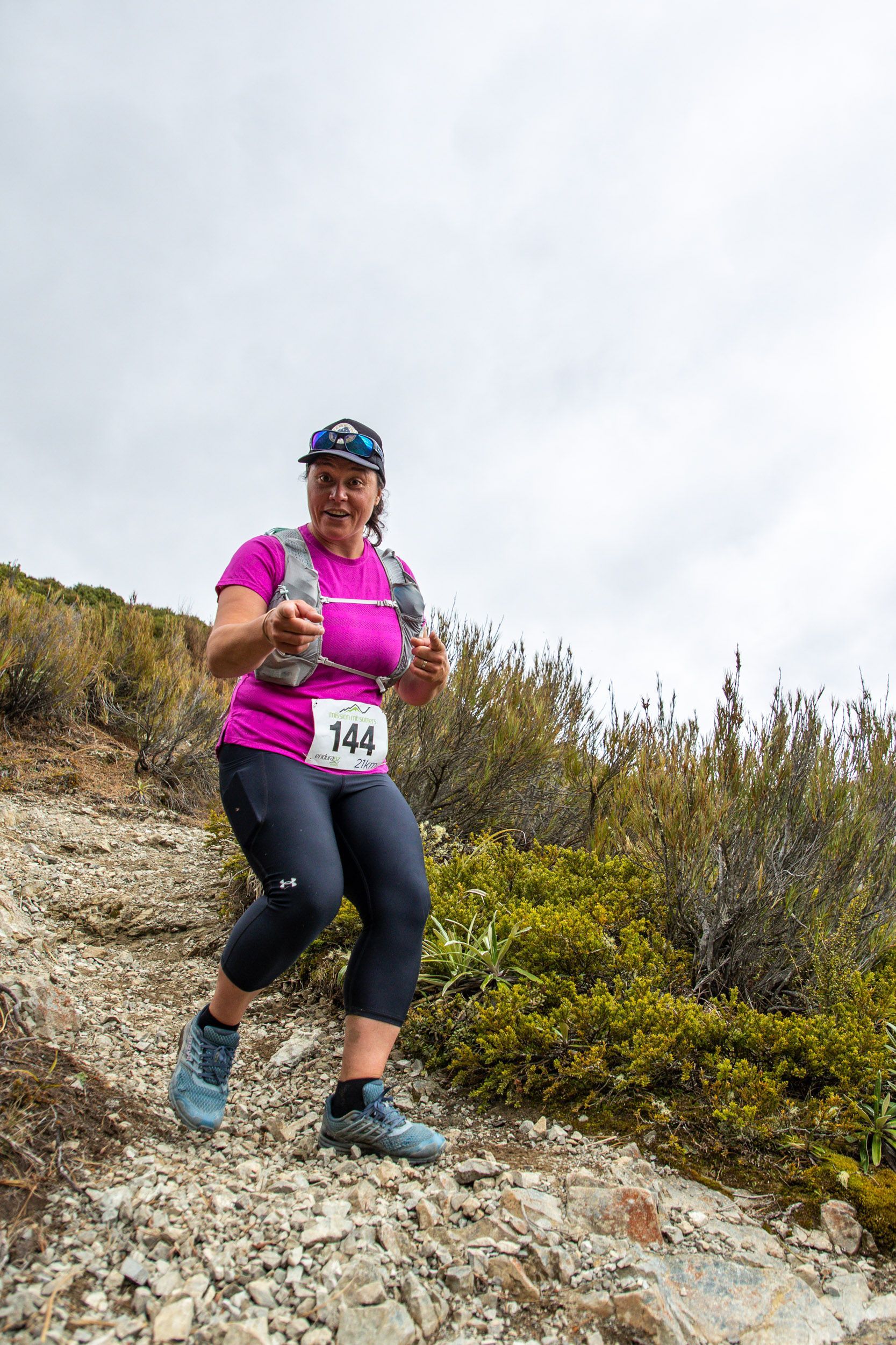 A woman is running up a rocky hill.
