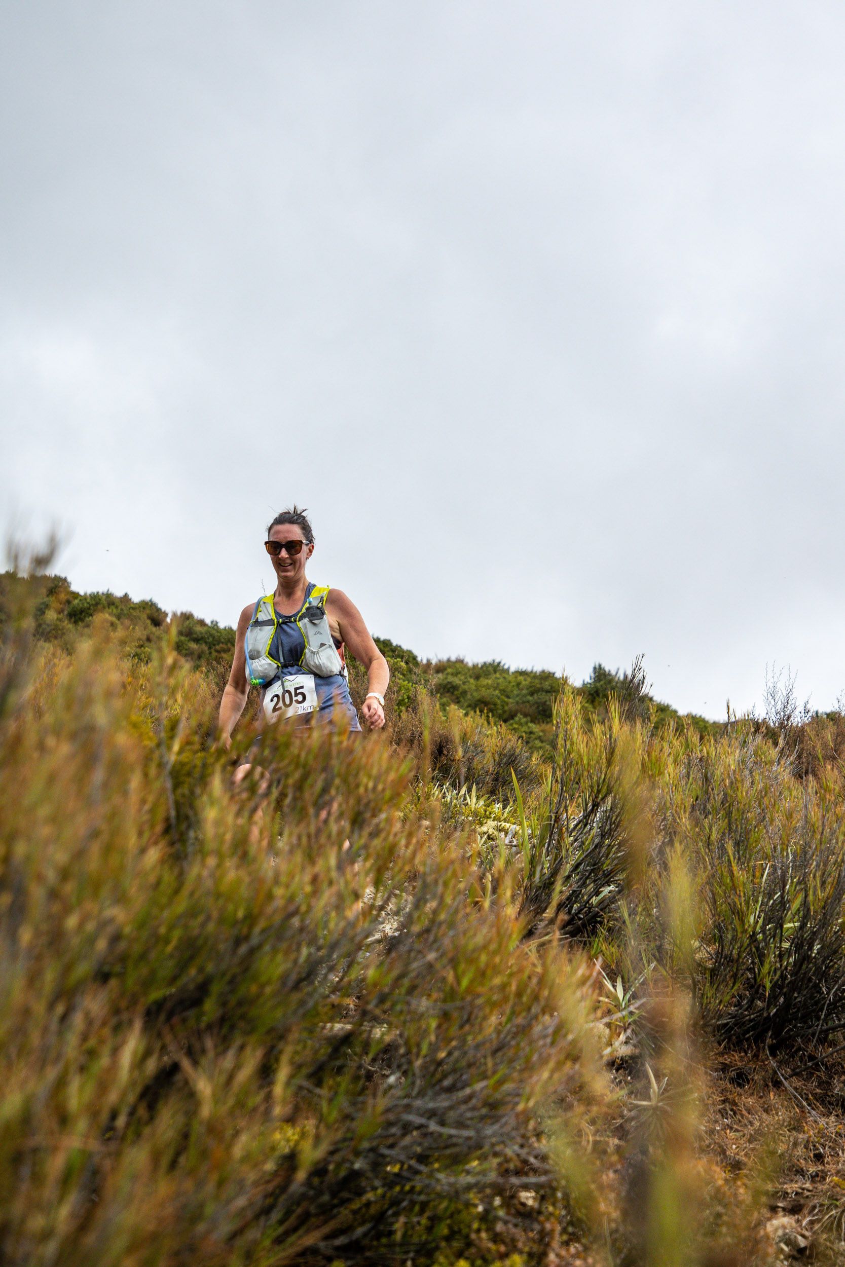 A man is running through a field of tall grass.
