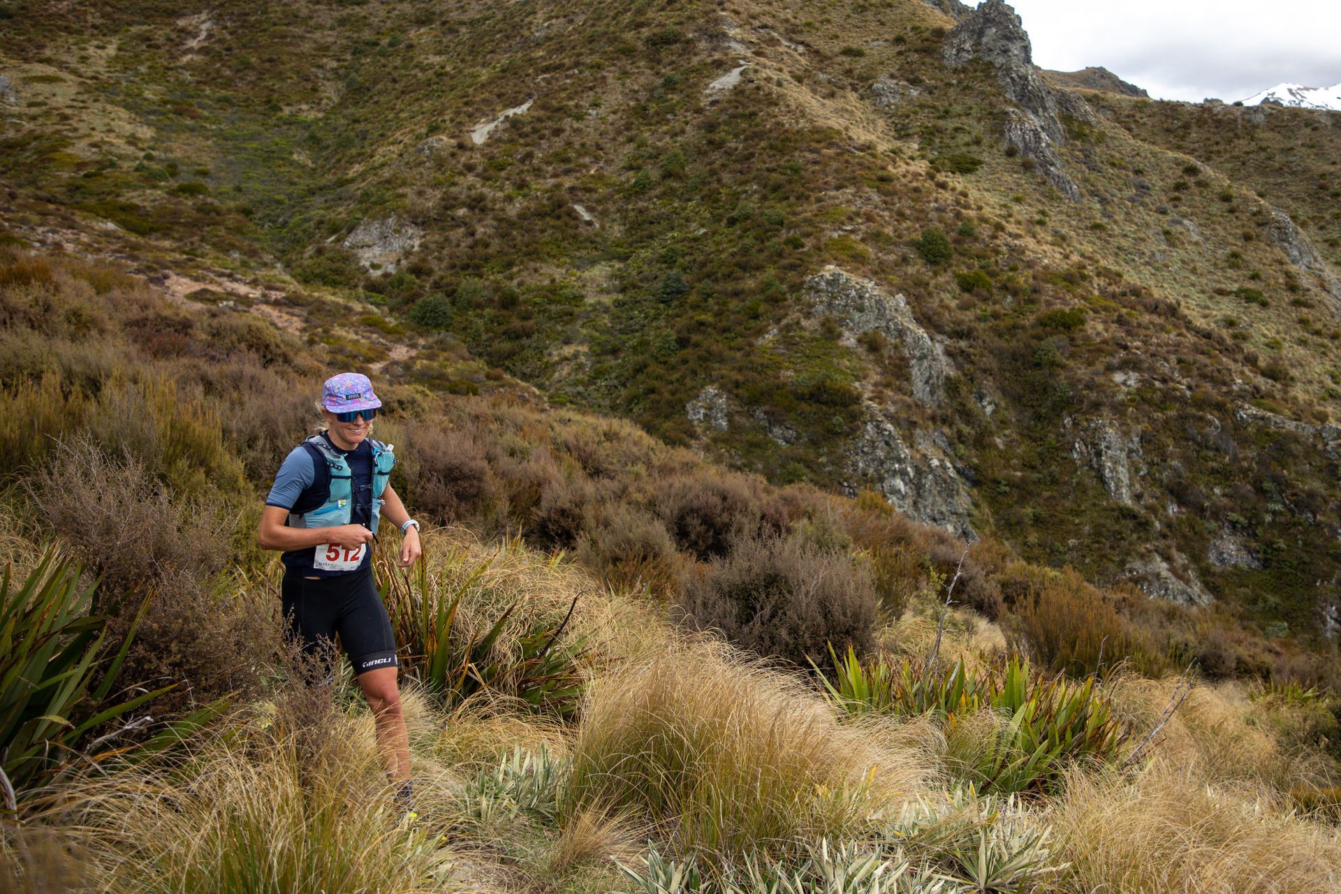 A man is running on a trail in the mountains.