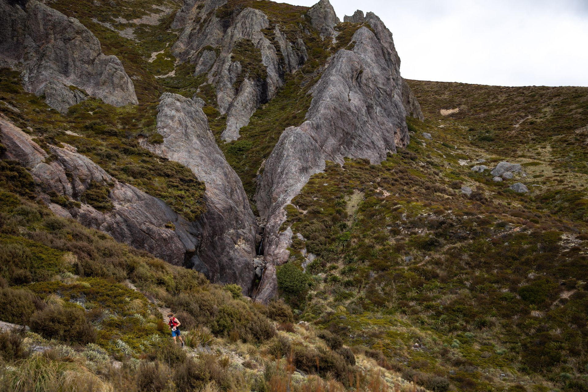 A person is walking down a hill in the mountains.