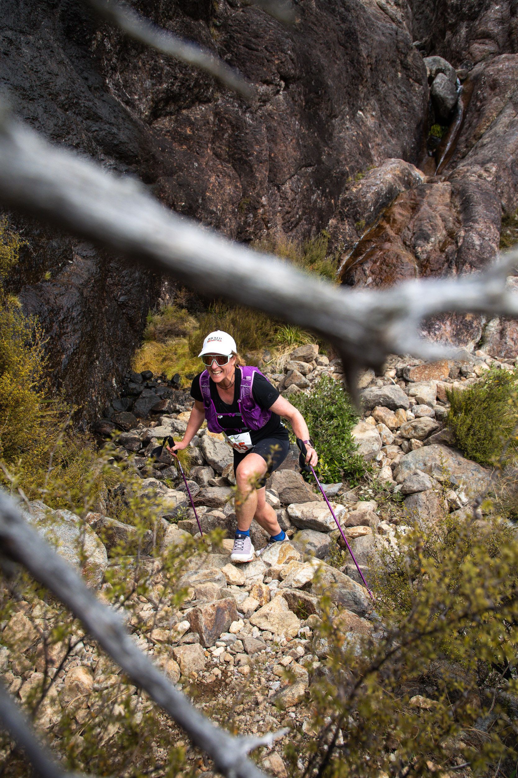 A woman is walking up a rocky hillside.