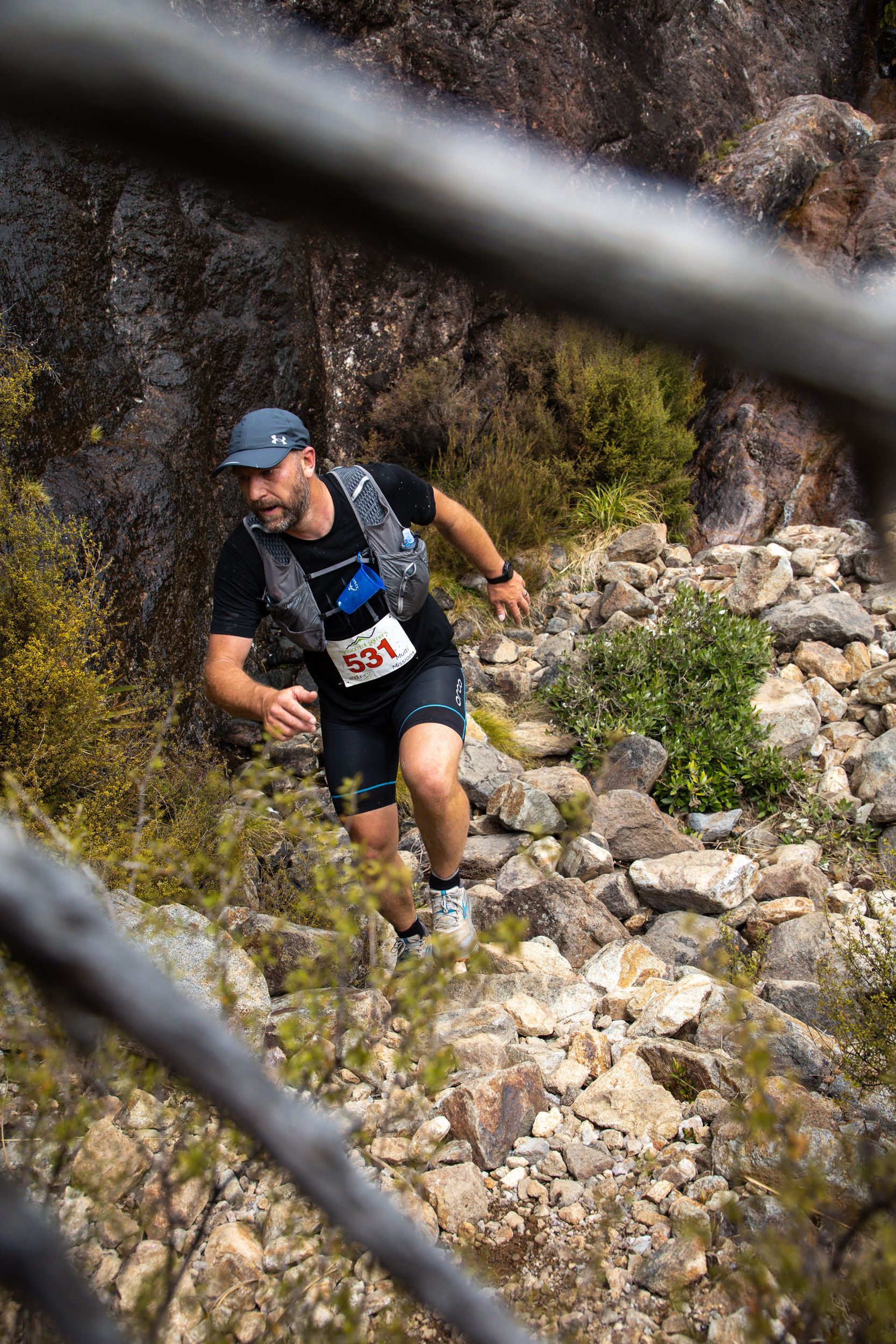A man is running up a rocky hill.