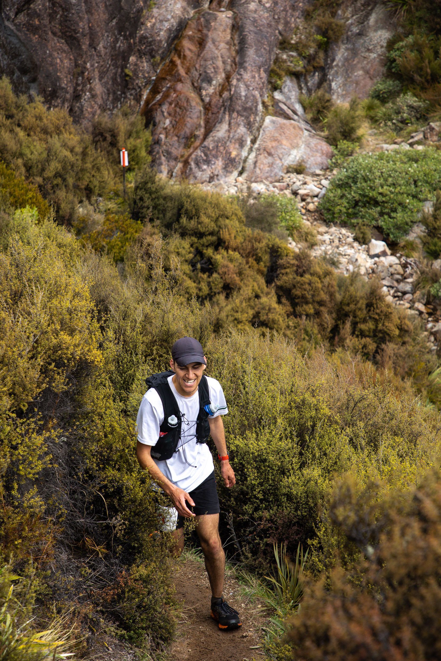 A man is walking down a trail in the woods.