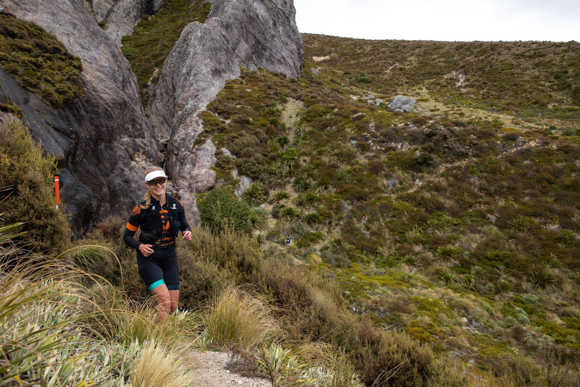 A man is running down a hill in the mountains.