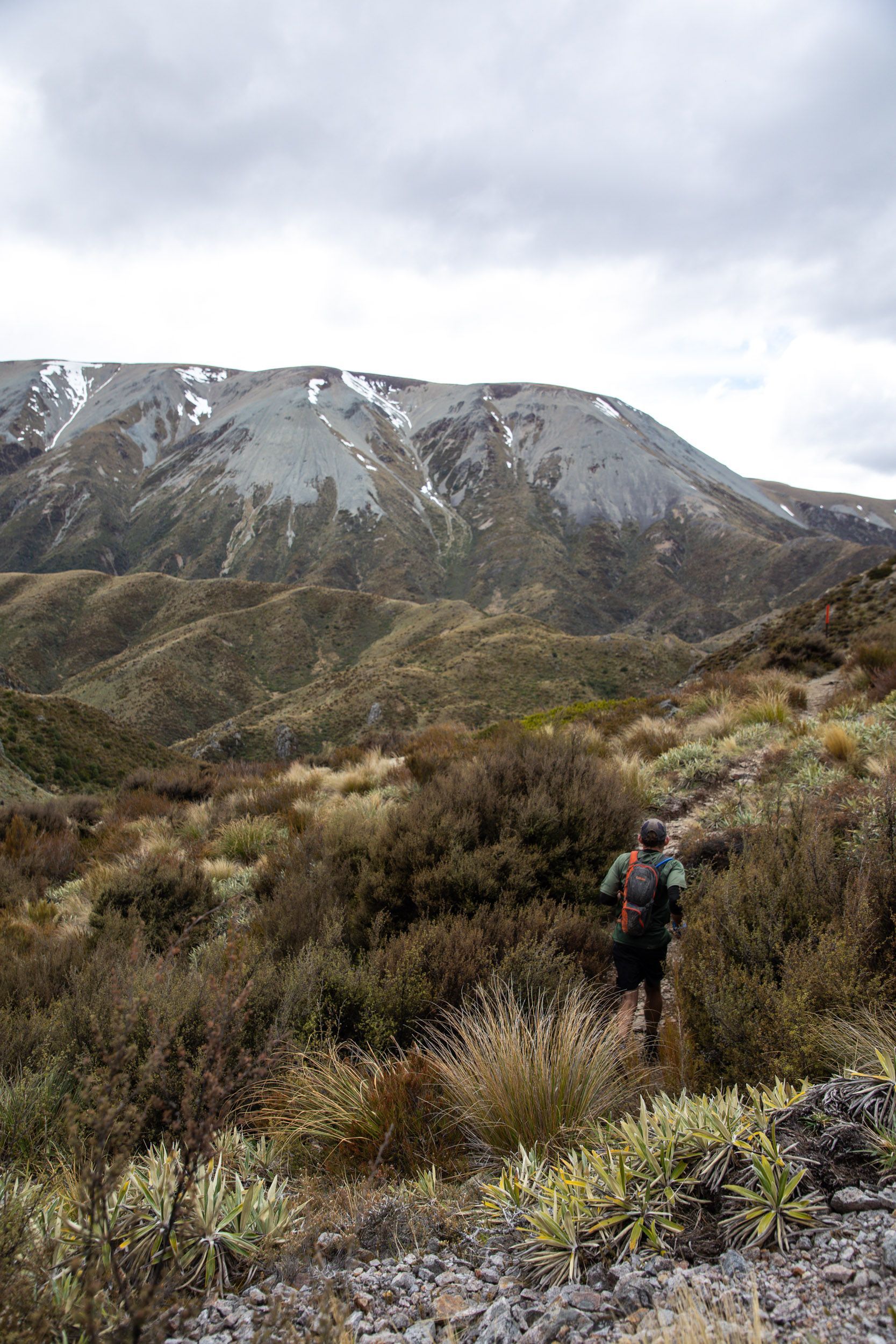 A person is hiking in the mountains with a backpack.