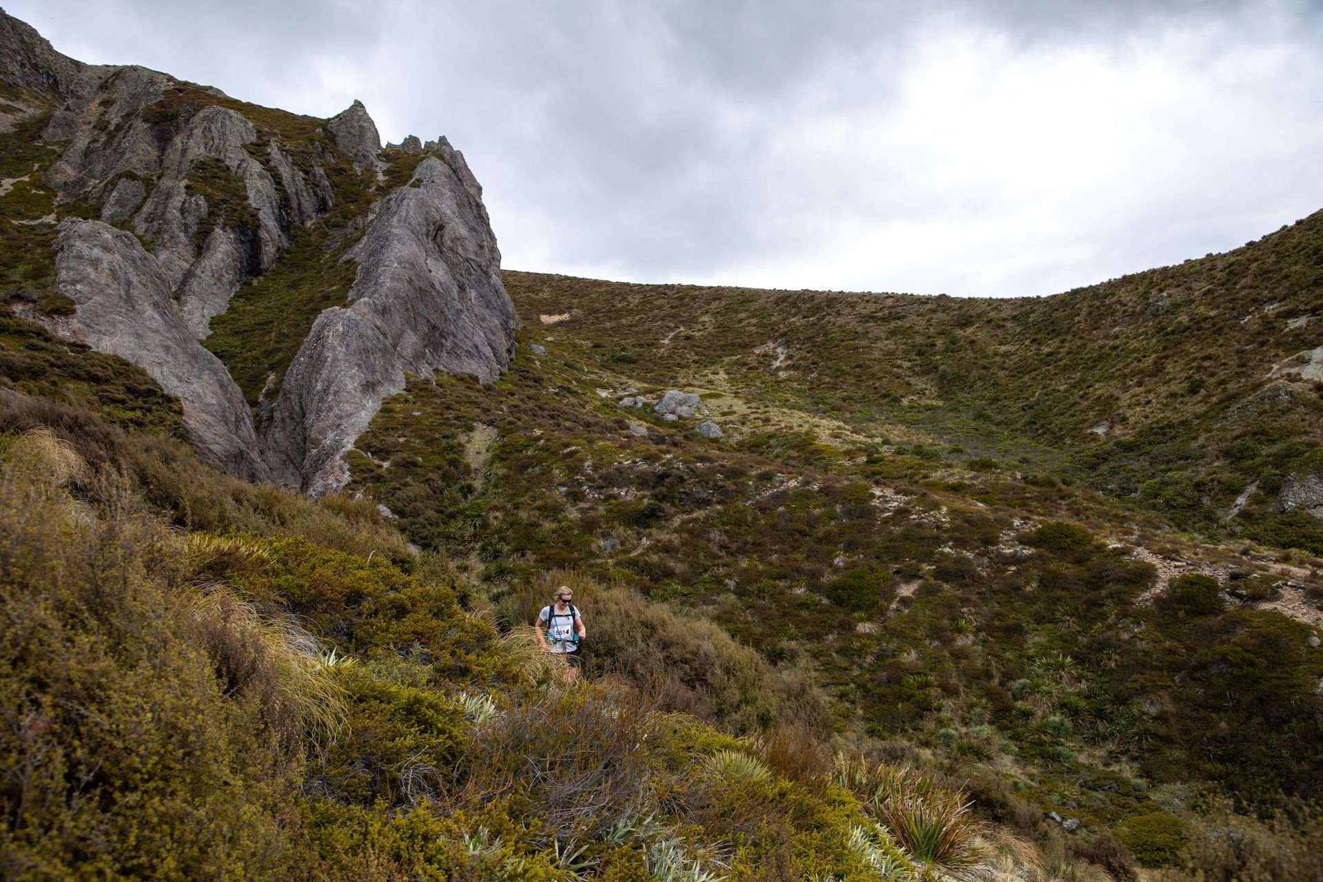 A person is walking up a hill in the mountains.