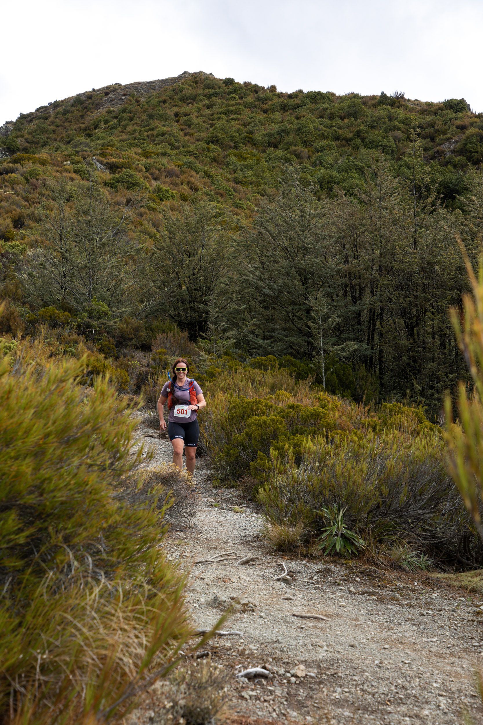 A person is walking down a dirt path in the woods.