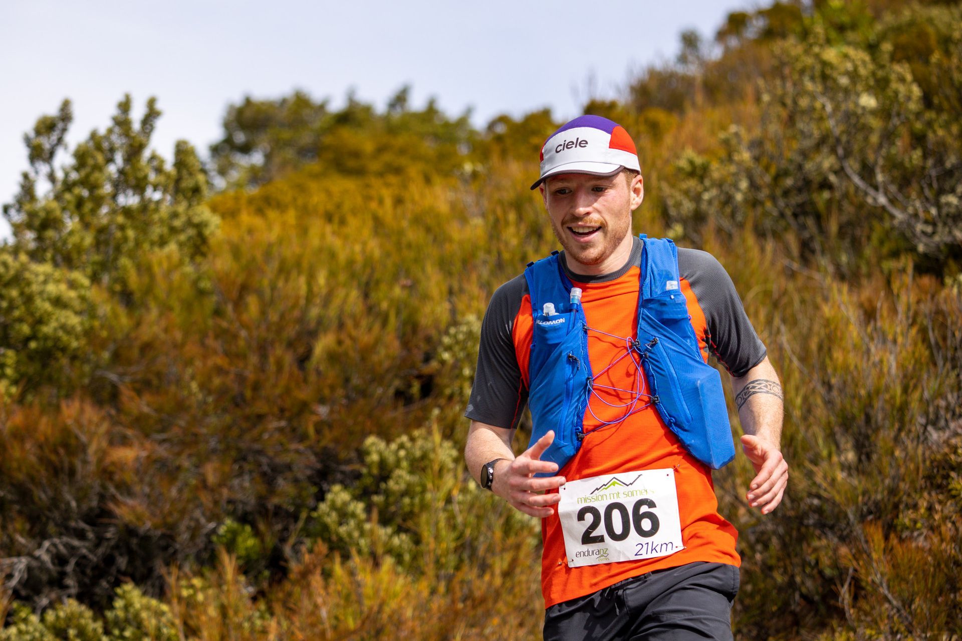 A man is running a trail race in the woods.