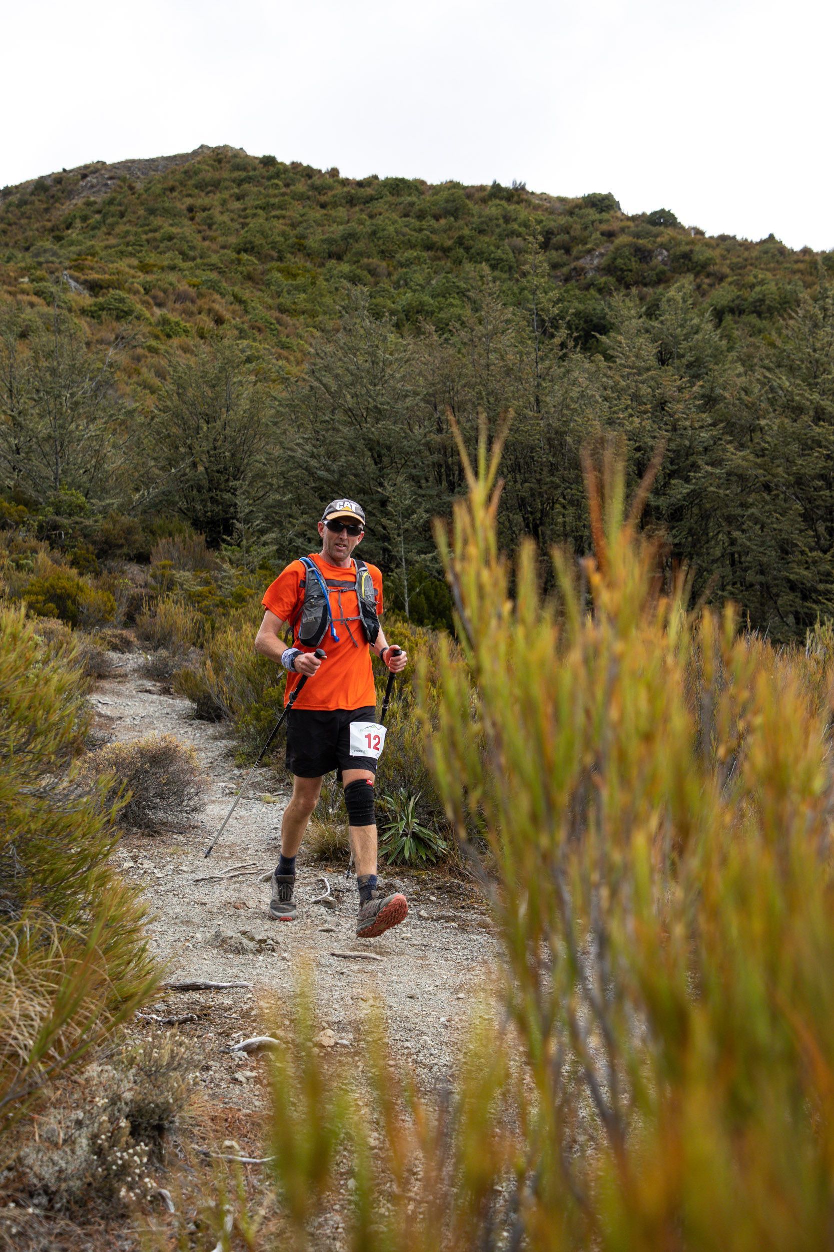 A man is running on a trail in the woods.