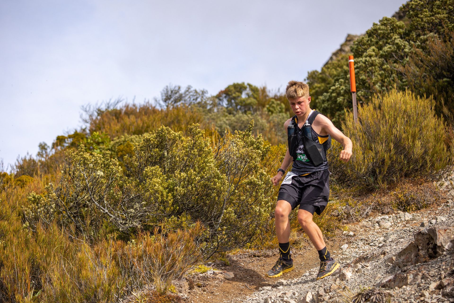 A man is running up a hill on a trail.