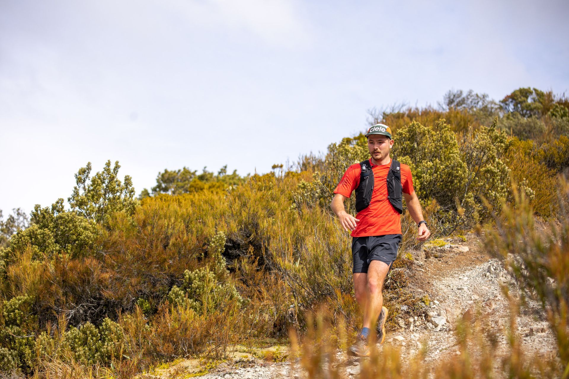 A man is running on a trail in the woods.