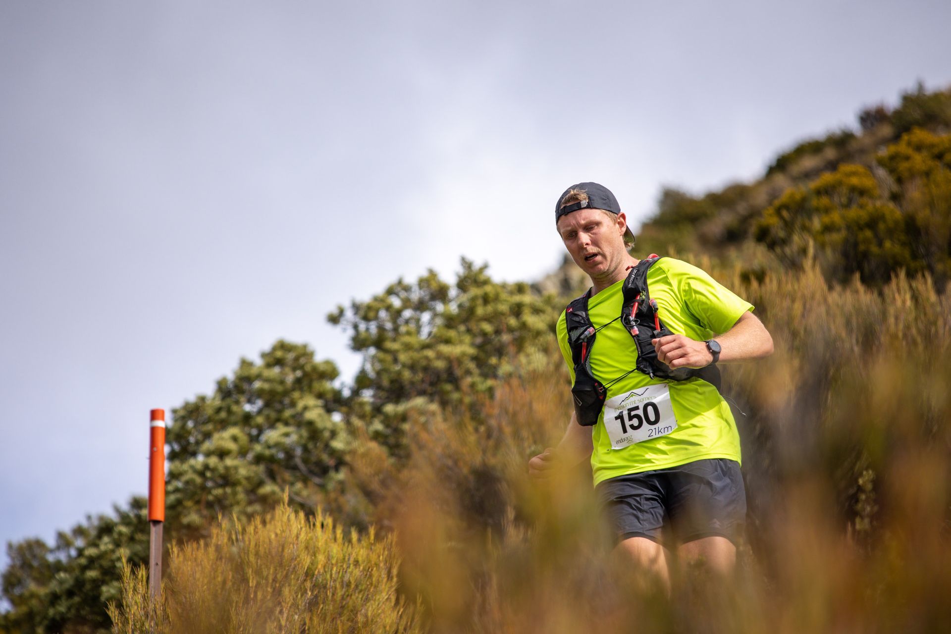 A man is running up a hill in a field.