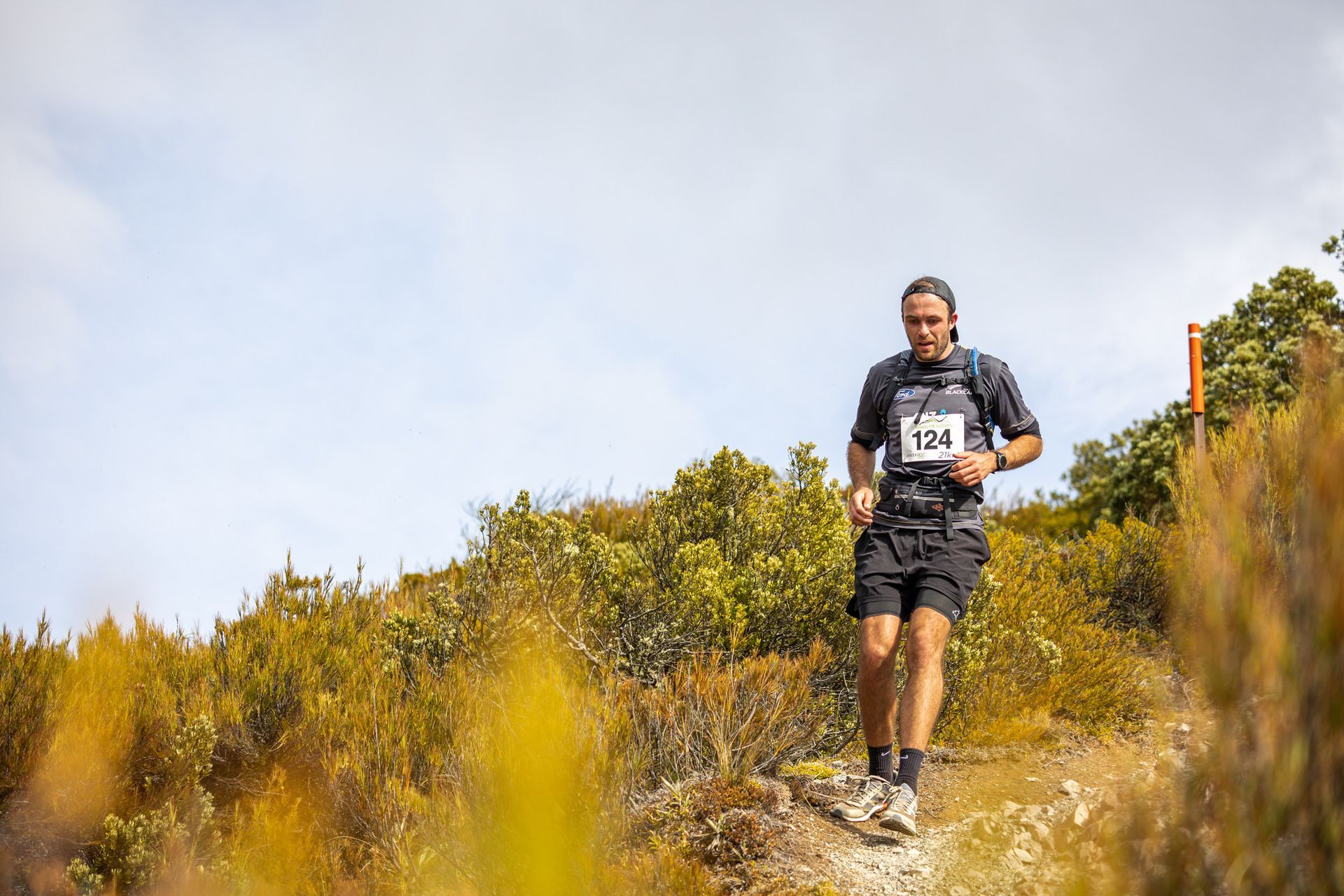 A man is running on a trail in the woods.