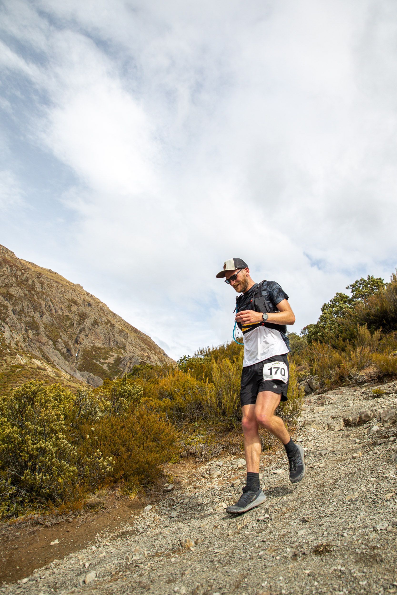 A man is running up a hill on a trail.