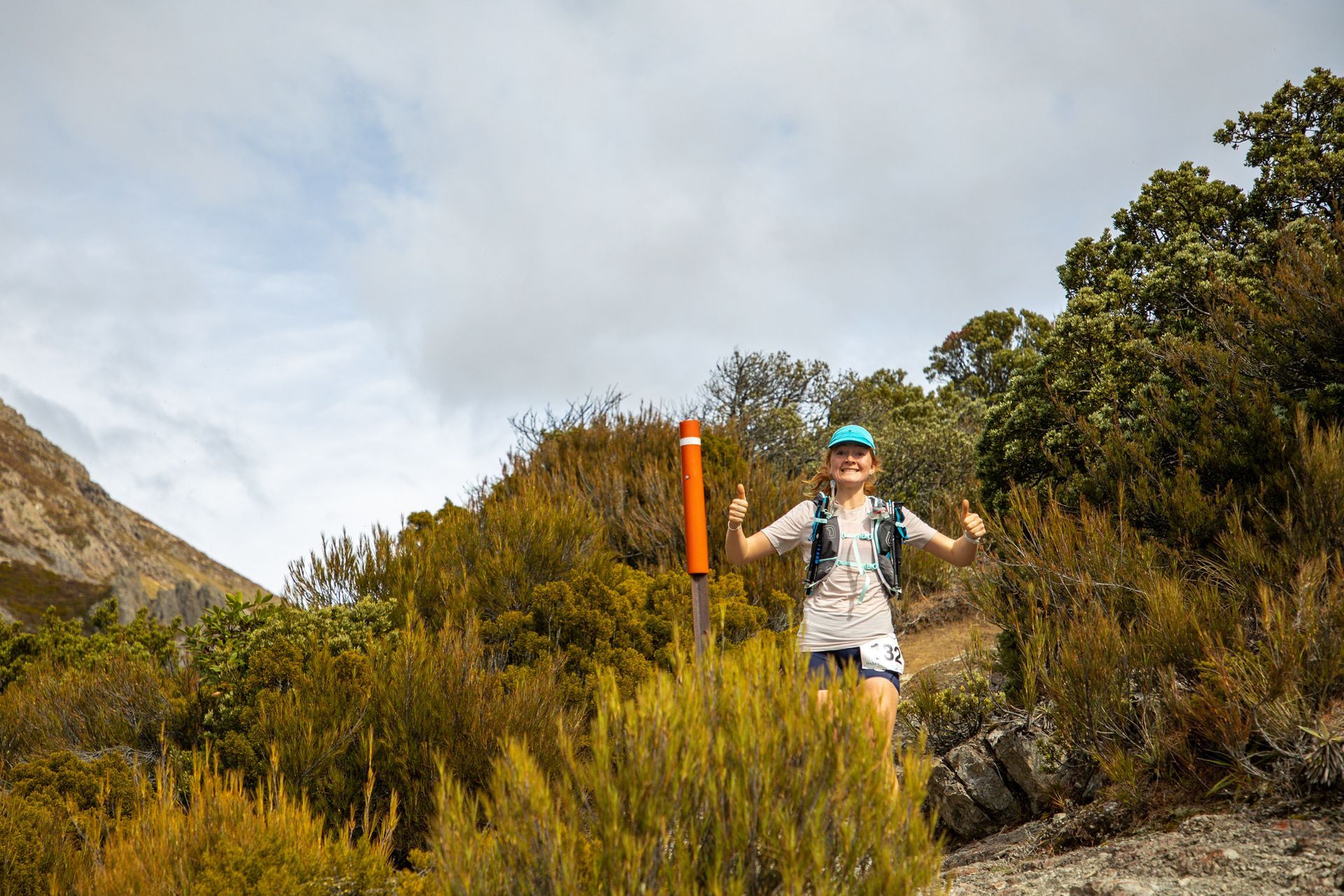 A woman is running on a trail in the woods.