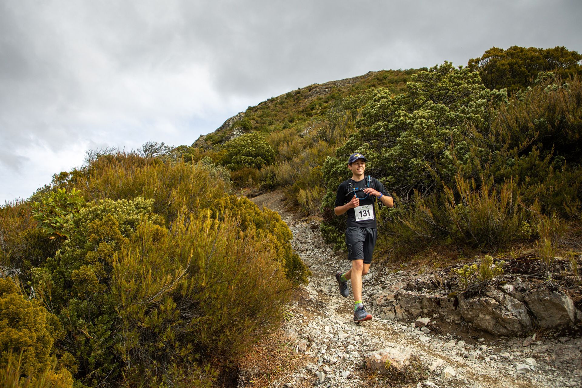 A man is running up a hill on a trail.