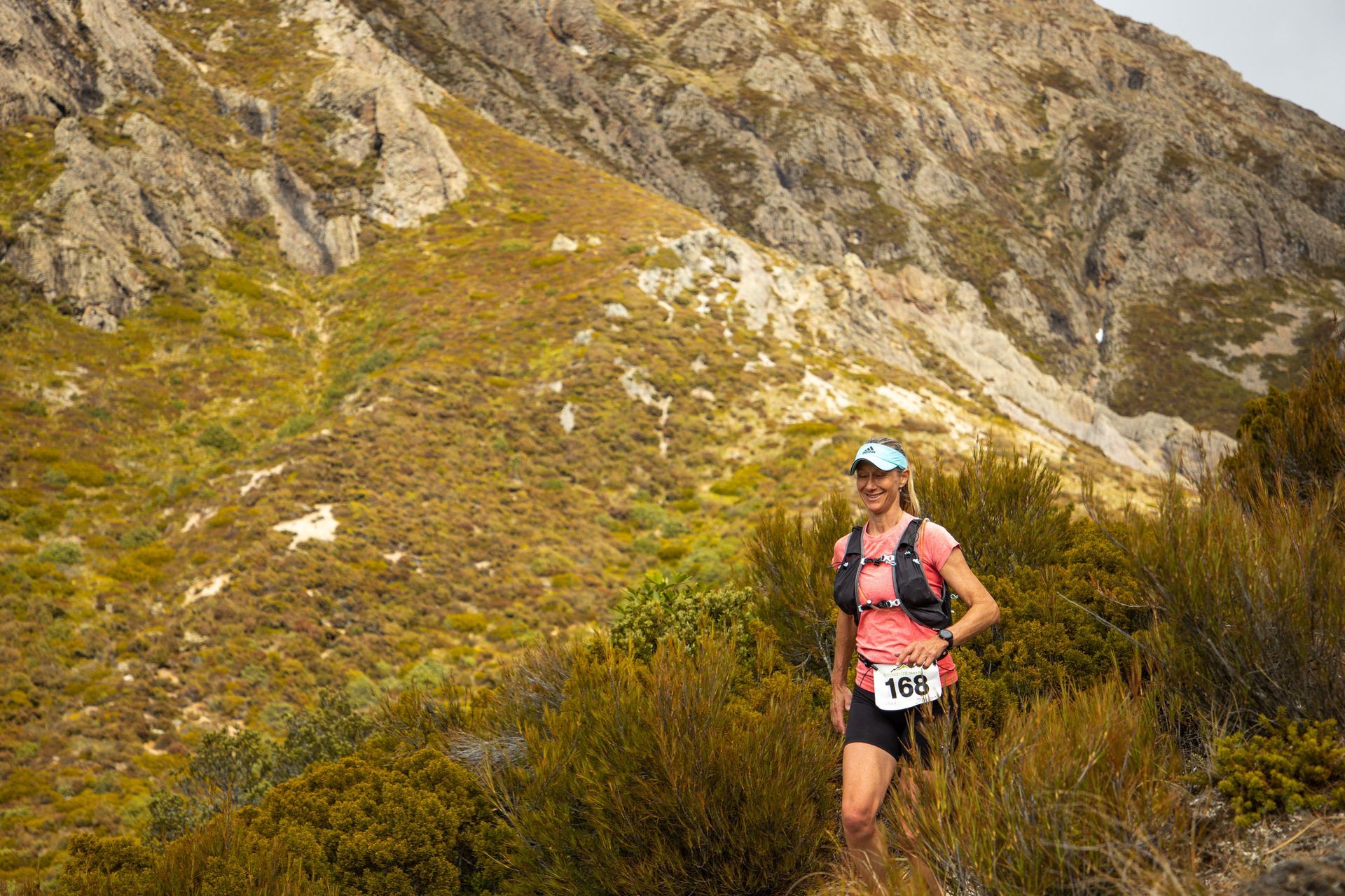 A woman is standing on top of a mountain.