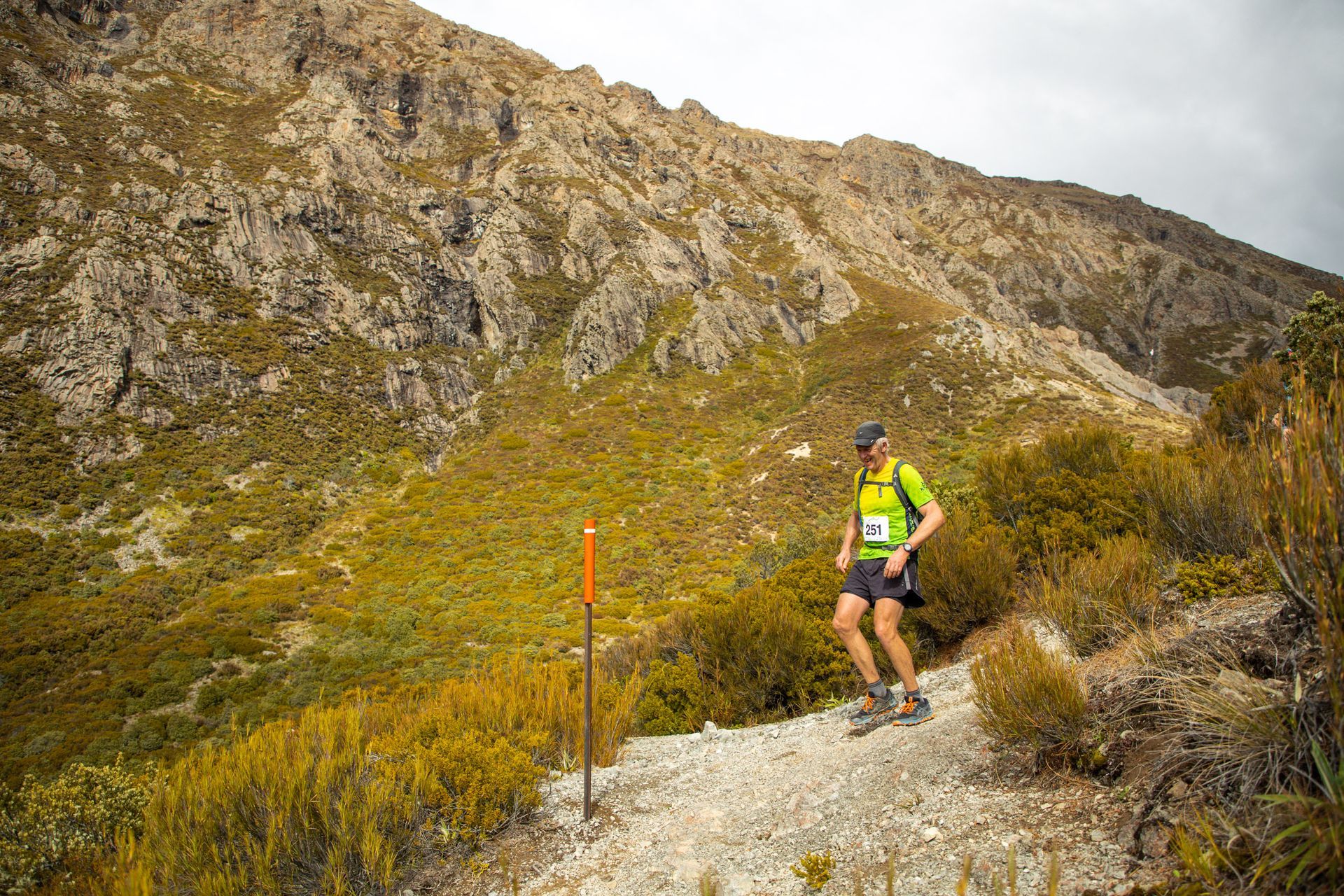 A man is walking on a trail in the mountains.