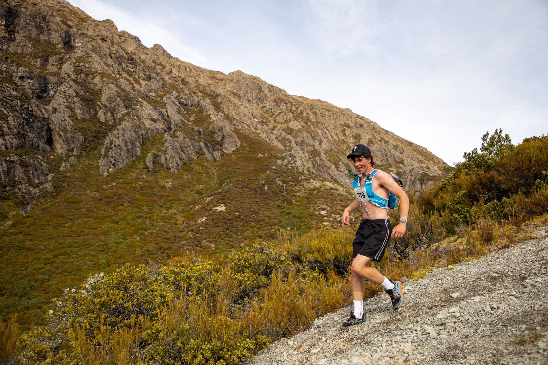 A man is running up a hill in the mountains.