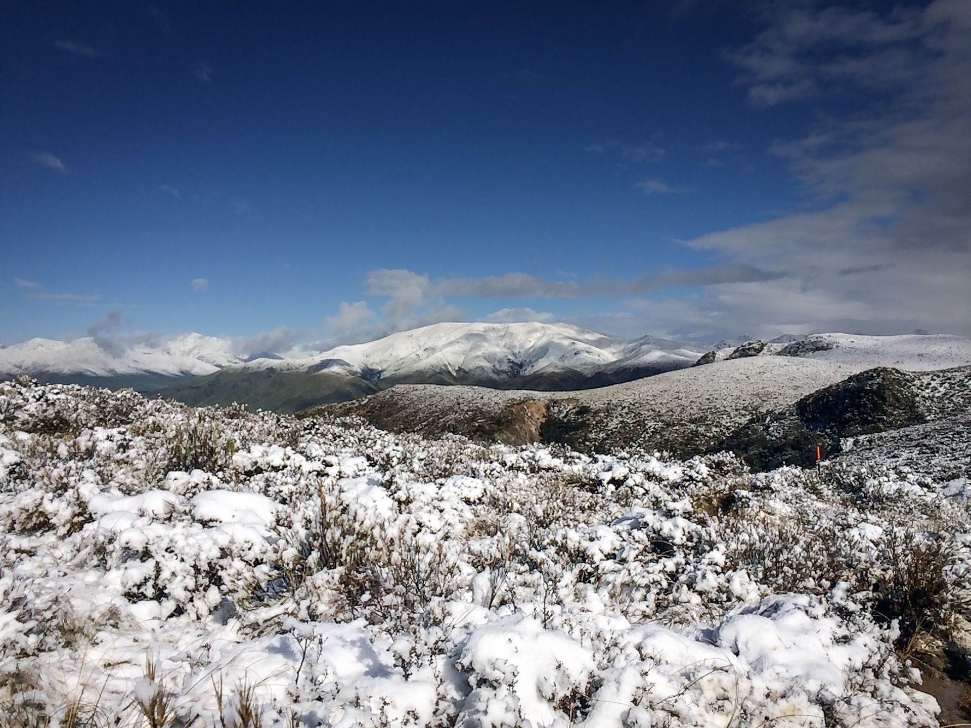 A snowy field with mountains in the background