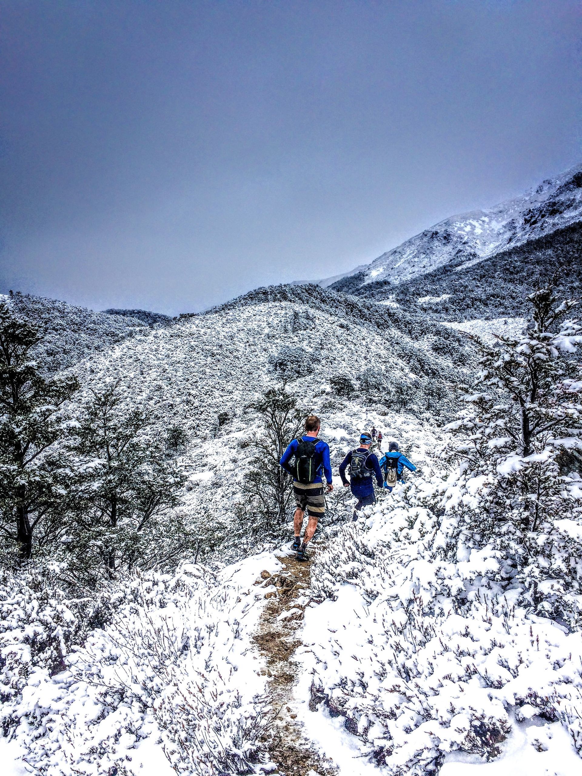 A group of people are hiking up a snowy mountain.