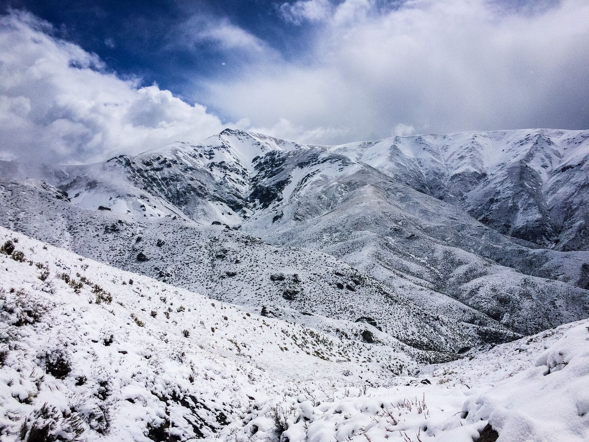 A snowy mountain range with a blue sky in the background