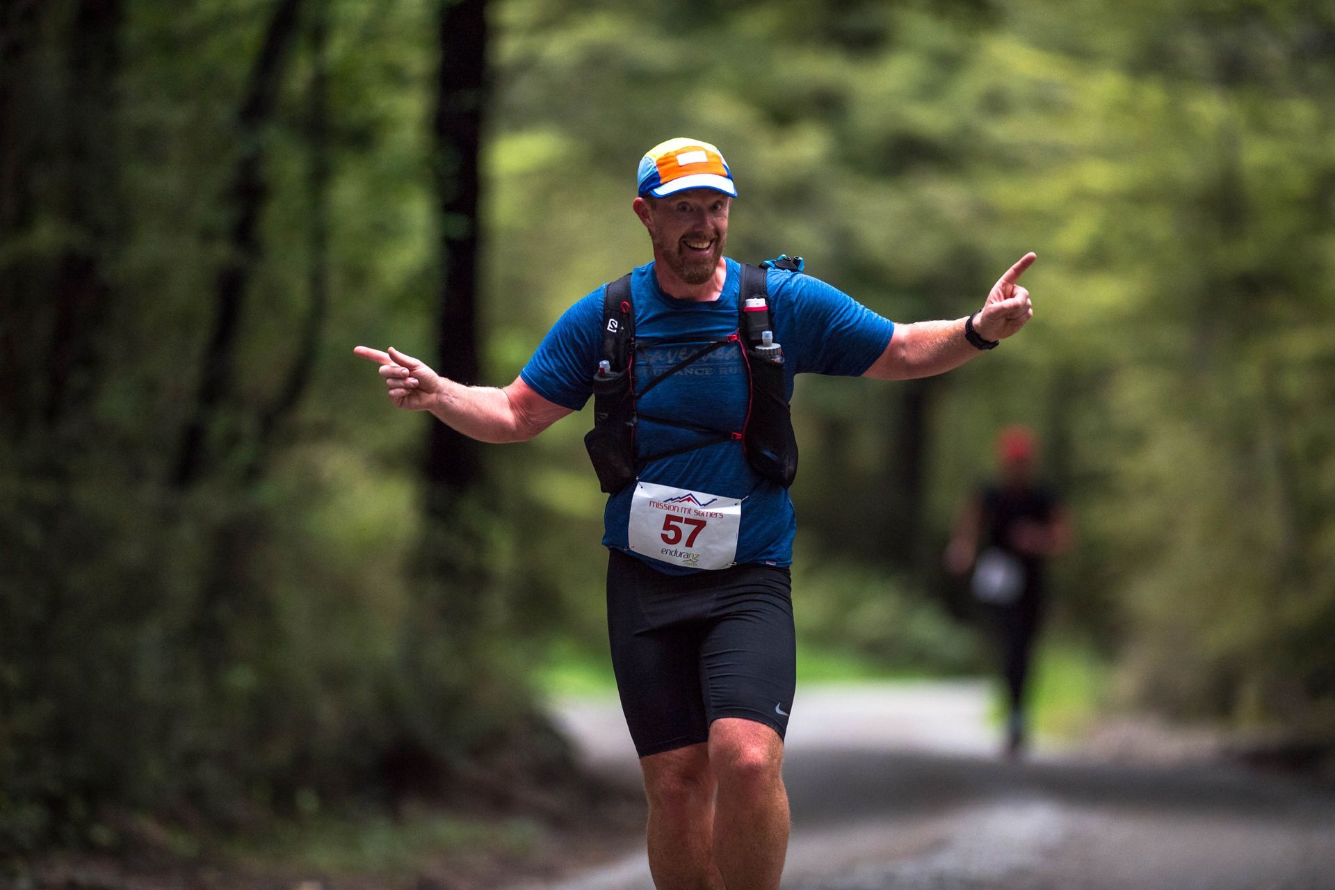 A man is running down a path with his arms outstretched.