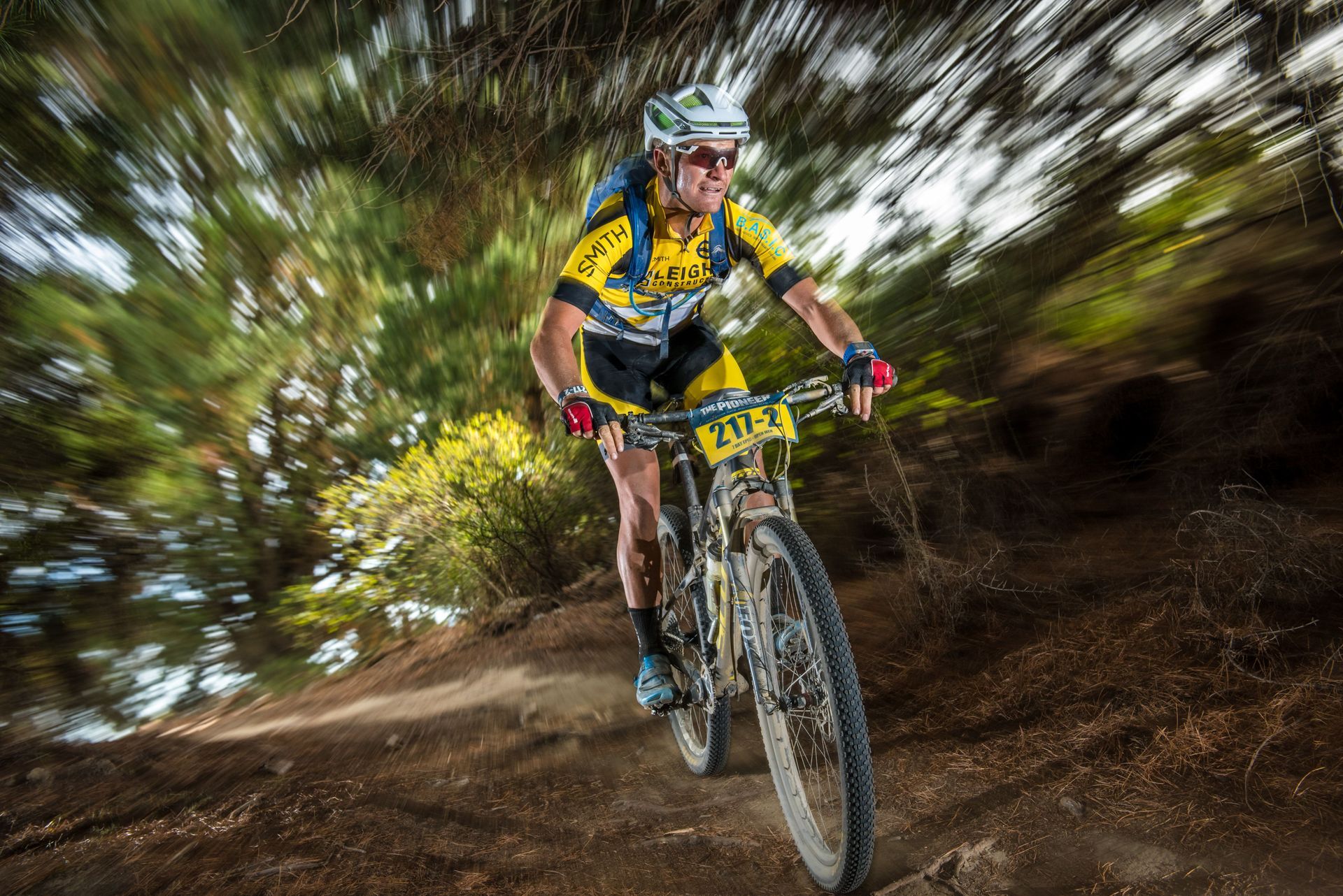 A man is riding a bike on a trail in the woods.