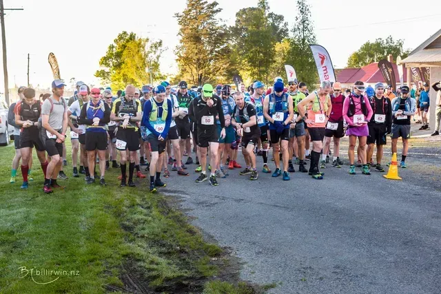 A group of people are standing on the side of a road.