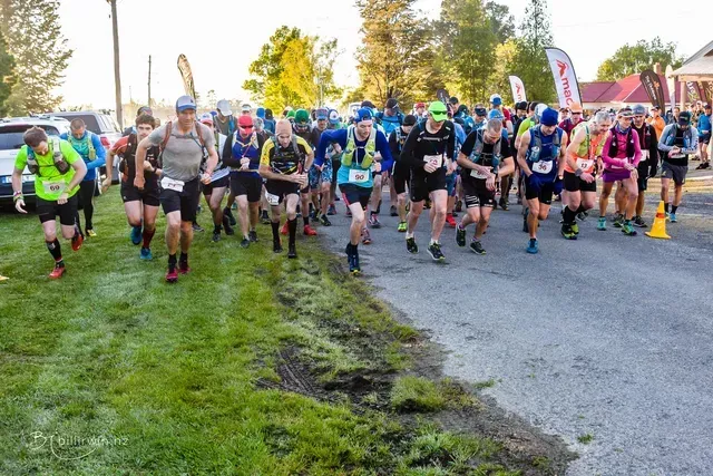 A group of people are running down a road.