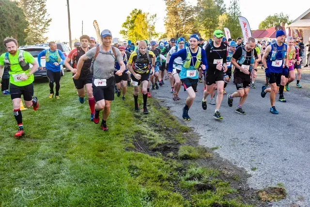 A group of people are running down a road.