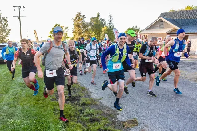 A group of people are running down a road.