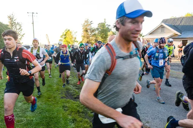 A group of people are running down a road.