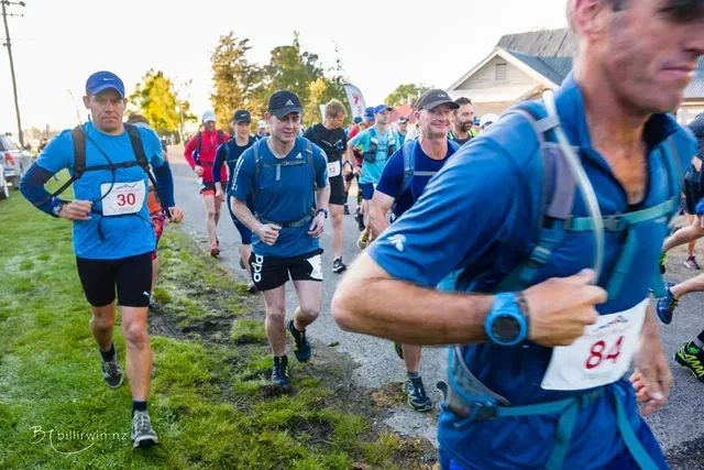 A group of men are running down a street.
