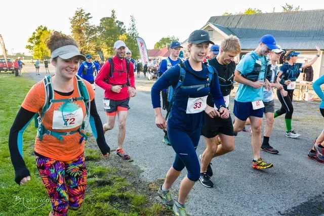 A group of people are running down a road.