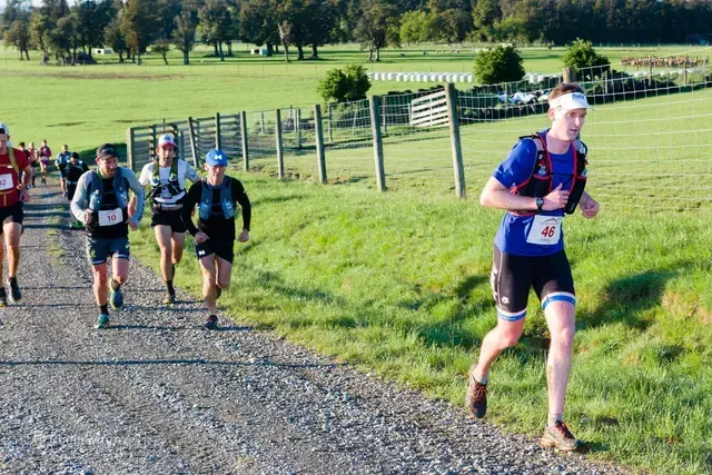 A group of people are running down a dirt road.