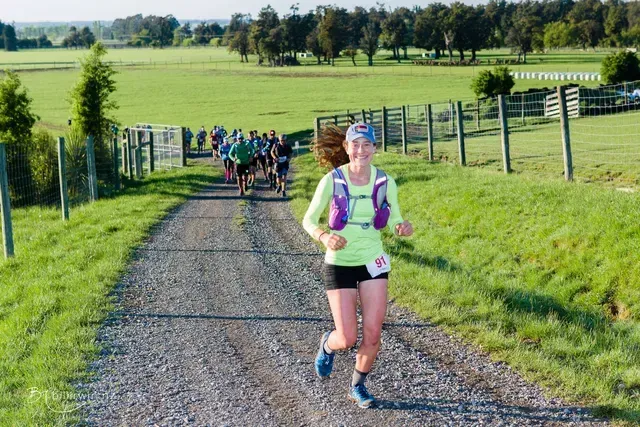 A group of people are running down a dirt road.